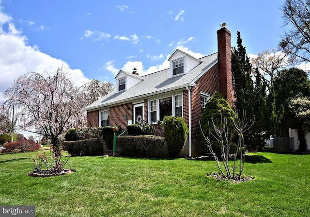 view of front facade with brick siding, a chimney, roof with shingles, and a front lawn