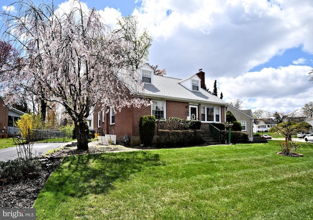 view of home's exterior with fence, brick siding, a chimney, concrete driveway, and a yard