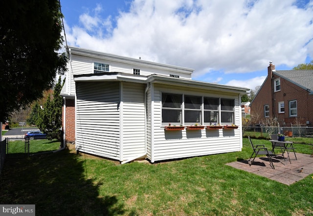 back of property with fence, a yard, and a patio area