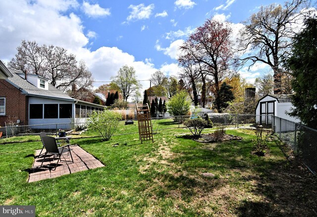 view of yard with a sunroom, a fenced backyard, and a patio area