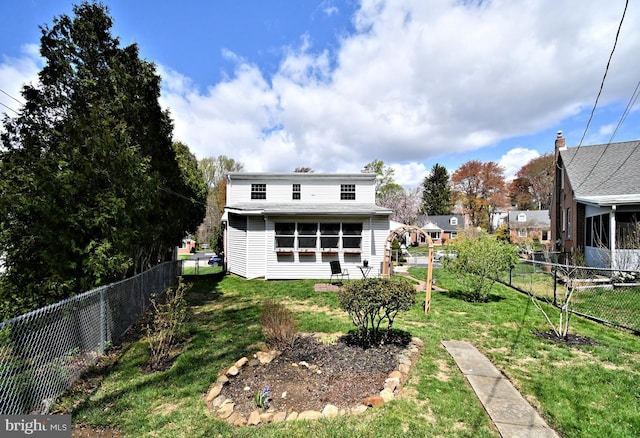 back of house with a lawn and a fenced backyard