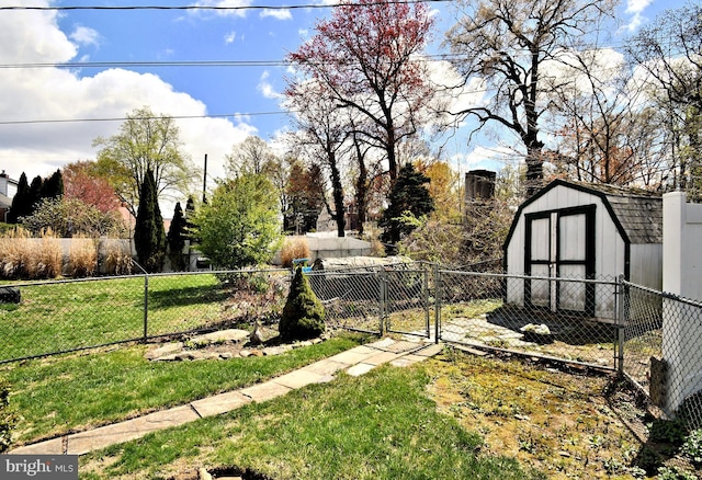 view of yard featuring a storage unit, a gate, fence, and an outdoor structure