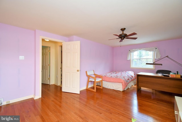 bedroom featuring baseboards, ceiling fan, and wood finished floors