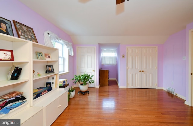 interior space featuring baseboards, a ceiling fan, light wood-style flooring, and visible vents