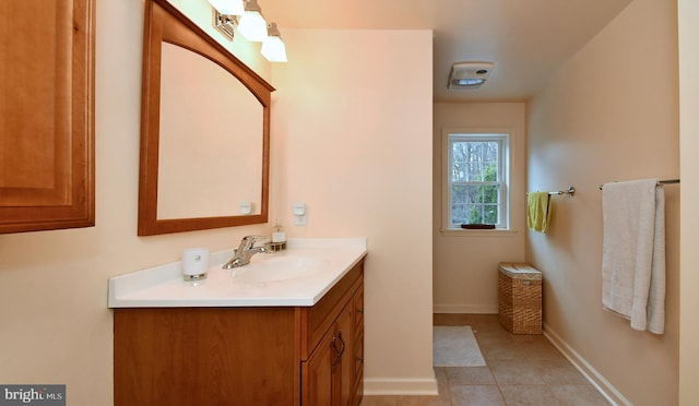bathroom with vanity, baseboards, and tile patterned flooring