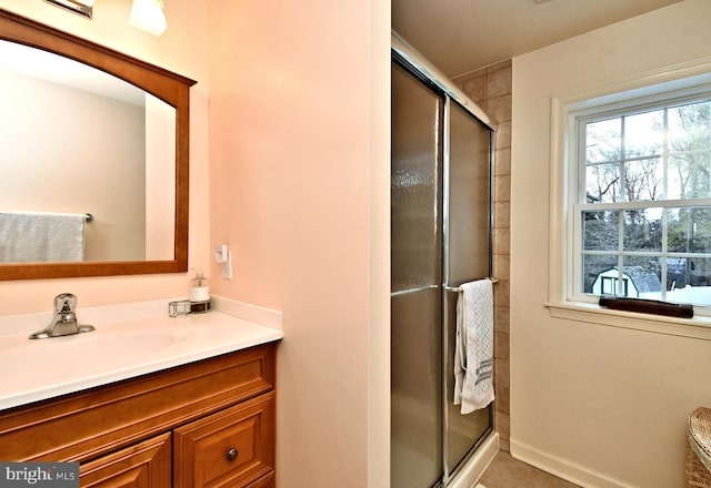 full bathroom featuring vanity, a stall shower, and a wealth of natural light