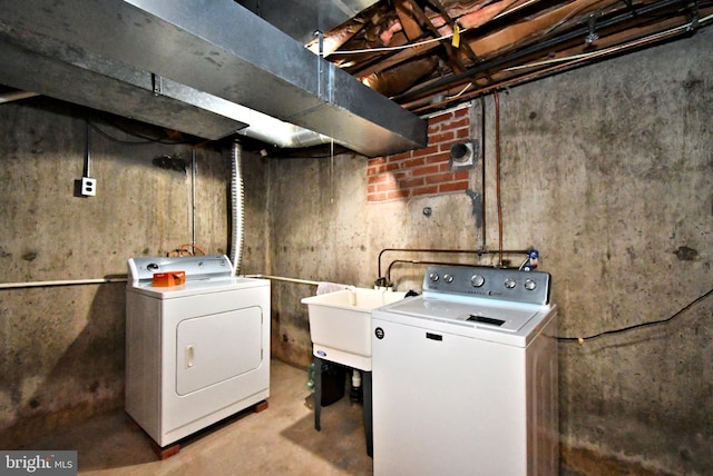 washroom featuring washing machine and clothes dryer, laundry area, and a sink