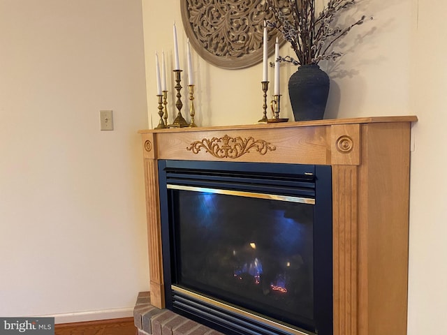 interior details featuring a glass covered fireplace and baseboards