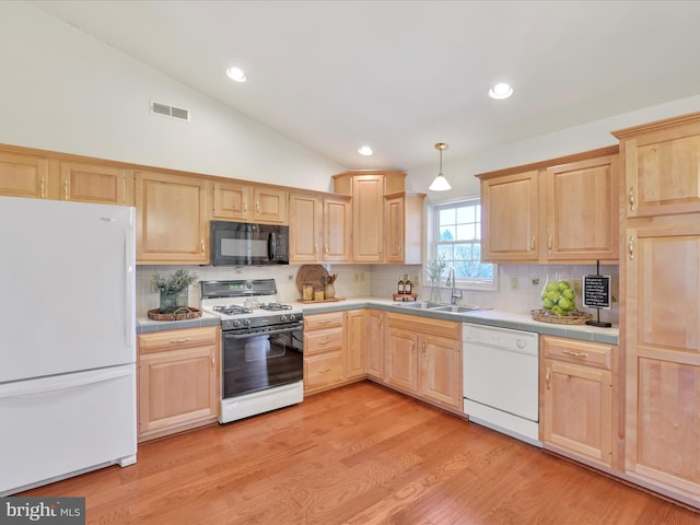 kitchen with tile countertops, white appliances, light brown cabinetry, and a sink