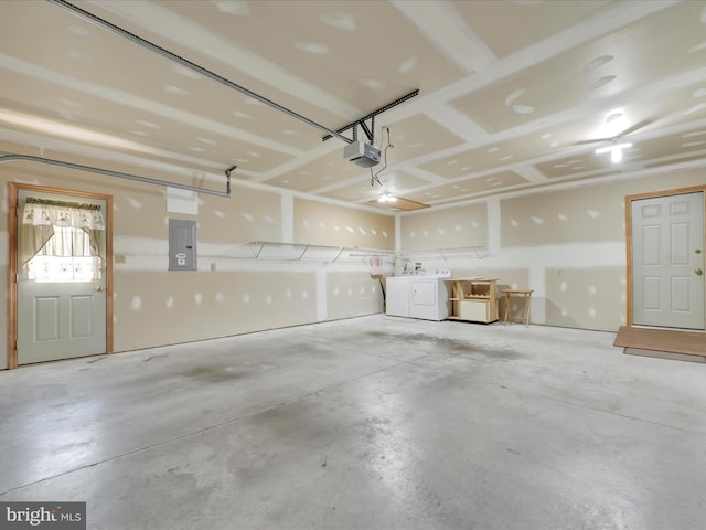 garage with washer and dryer, a garage door opener, and electric panel