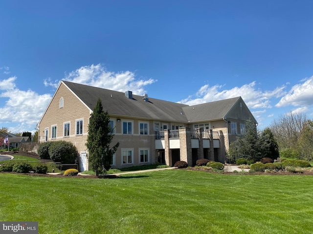 exterior space featuring brick siding and a front lawn