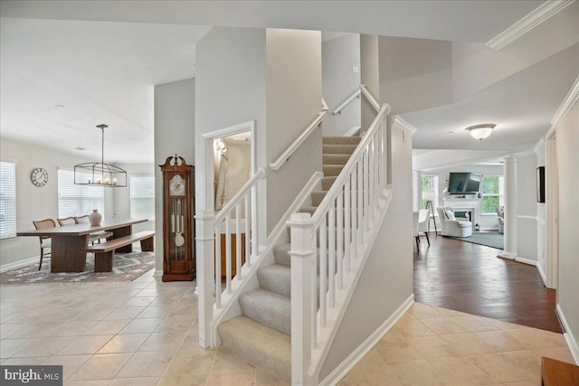 834 Oyster Bay Pl, Solomons, MD 20688 - staircase featuring tile patterned flooring, an inviting chandelier, baseboards, and a wealth of natural light