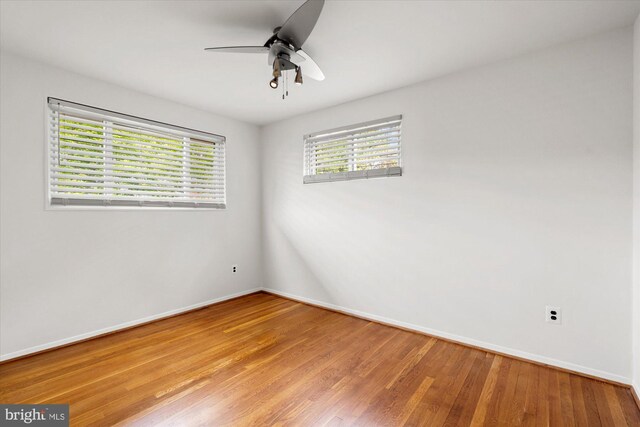 spare room featuring baseboards, ceiling fan, and wood finished floors