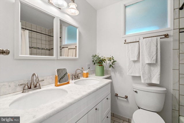 bathroom with double vanity, a sink, curtained shower, and toilet