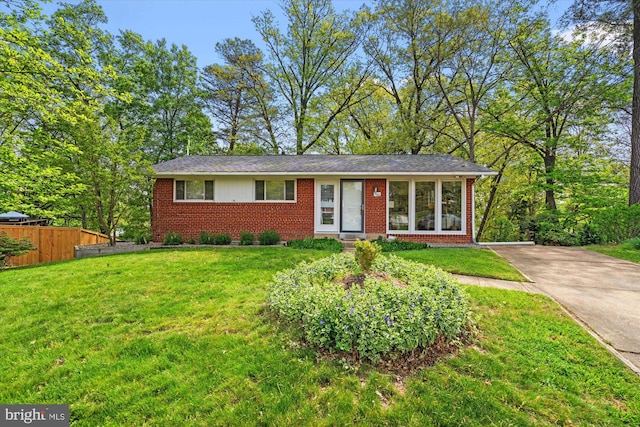 view of front of property with fence, a front yard, driveway, and brick siding