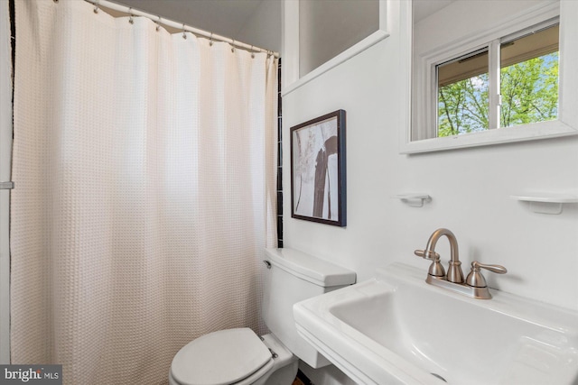 full bath featuring a sink, toilet, and a shower with shower curtain