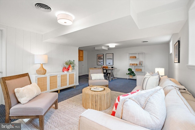 carpeted living area featuring visible vents and baseboards