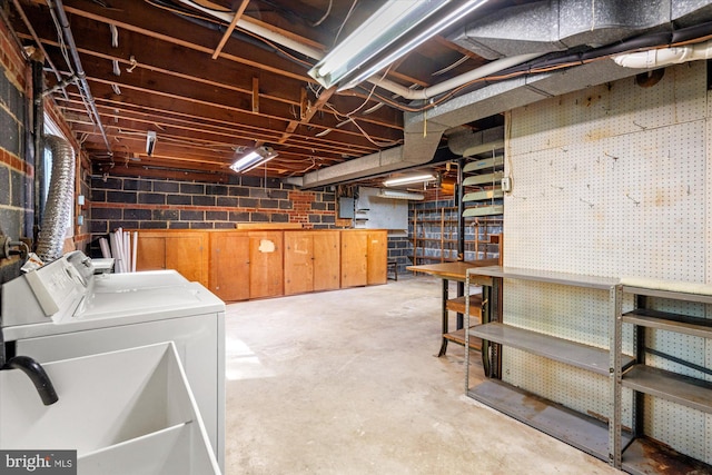 unfinished basement featuring a sink, independent washer and dryer, and a workshop area