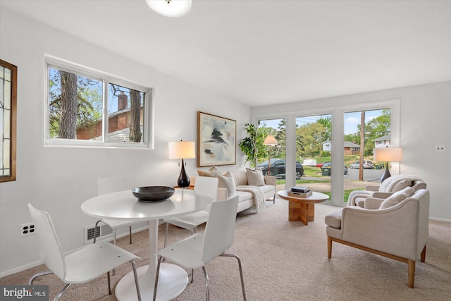 carpeted dining room with baseboards, a wealth of natural light, and visible vents
