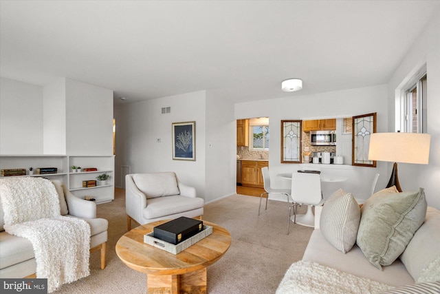 living area with light colored carpet and visible vents