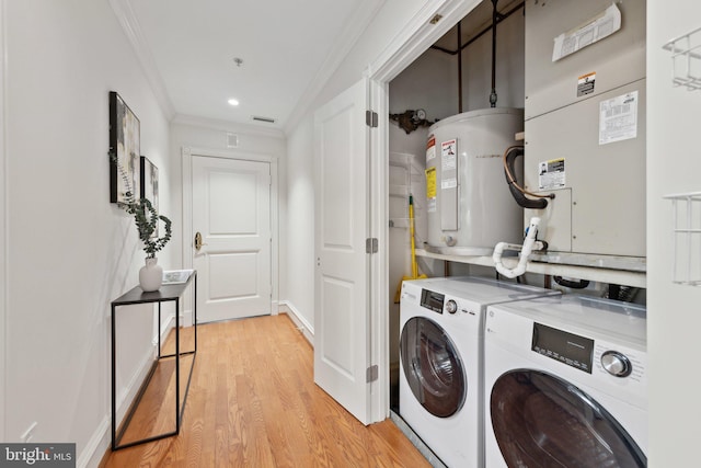 laundry room with laundry area, ornamental molding, electric water heater, light wood finished floors, and independent washer and dryer