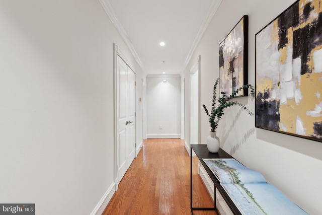 hall featuring crown molding, baseboards, recessed lighting, and light wood-style flooring
