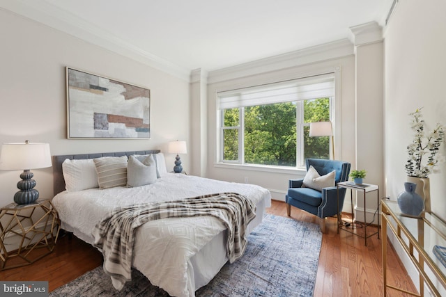 bedroom with crown molding and wood finished floors