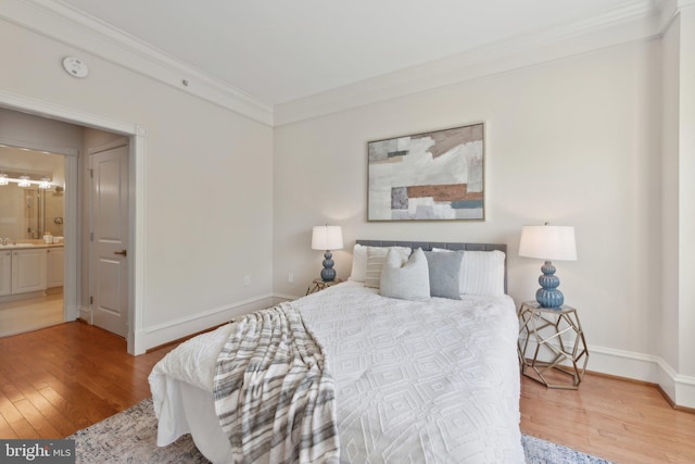 bedroom featuring crown molding, baseboards, and light wood finished floors