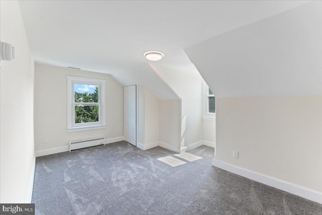 additional living space featuring baseboards, a baseboard heating unit, vaulted ceiling, and carpet floors