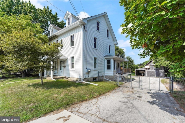 view of front facade with a front lawn, fence, a gate, and aphalt driveway