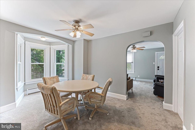 dining area with baseboards, arched walkways, ceiling fan, baseboard heating, and light colored carpet