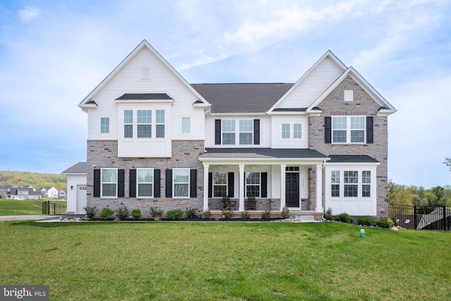craftsman-style house featuring a front yard, covered porch, and stone siding