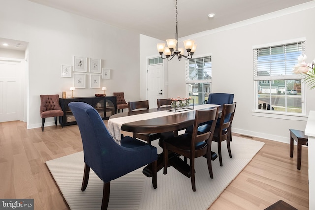 dining area featuring an inviting chandelier, baseboards, light wood-style flooring, and visible vents