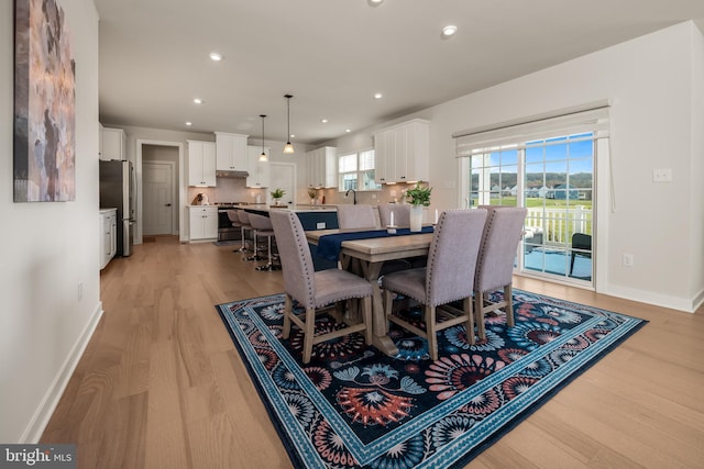 dining space featuring baseboards, recessed lighting, and light wood-style flooring