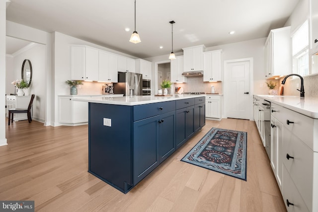 kitchen featuring stainless steel fridge, blue cabinets, decorative backsplash, and white cabinetry