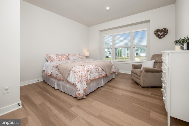 bedroom with baseboards and light wood-type flooring