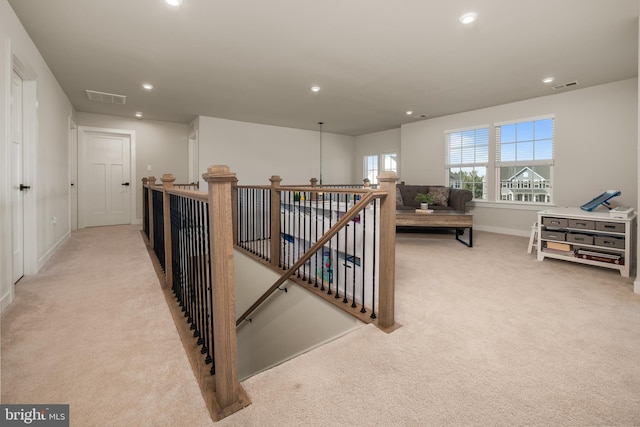 interior space with baseboards, visible vents, carpet flooring, and an upstairs landing
