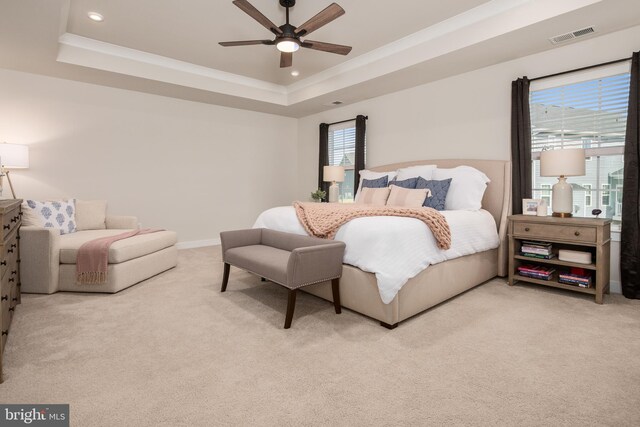 bedroom featuring a raised ceiling, multiple windows, recessed lighting, and light colored carpet