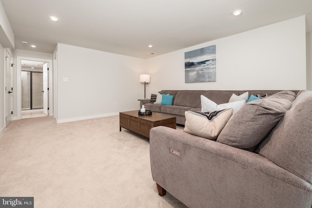 living area with baseboards, recessed lighting, and light colored carpet