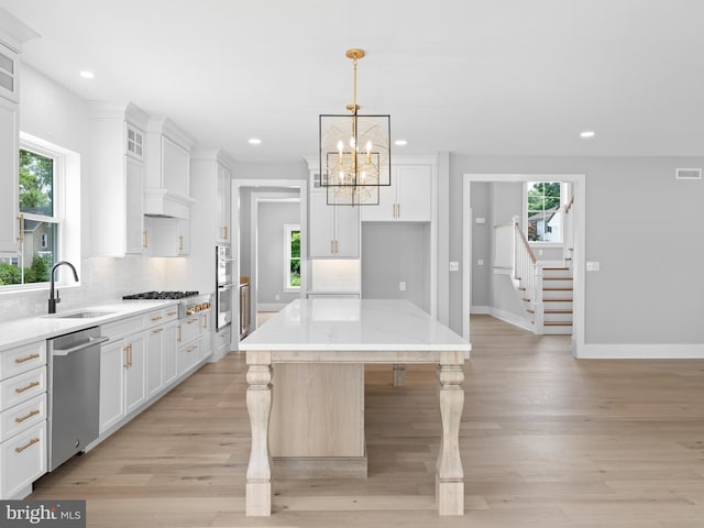 kitchen with appliances with stainless steel finishes, recessed lighting, a sink, and a wealth of natural light