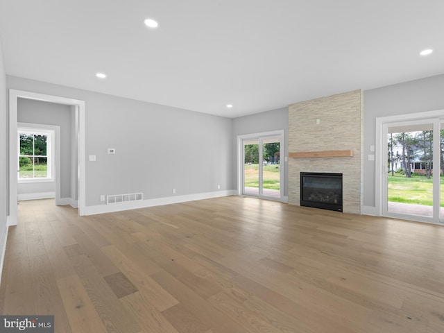 unfurnished living room featuring visible vents, recessed lighting, plenty of natural light, and light wood-style floors
