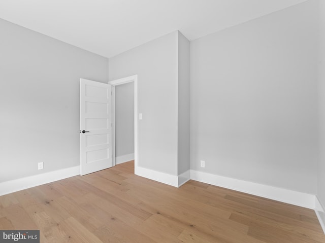 unfurnished room with light wood-style floors and baseboards