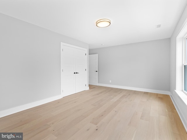 empty room with light wood finished floors and baseboards