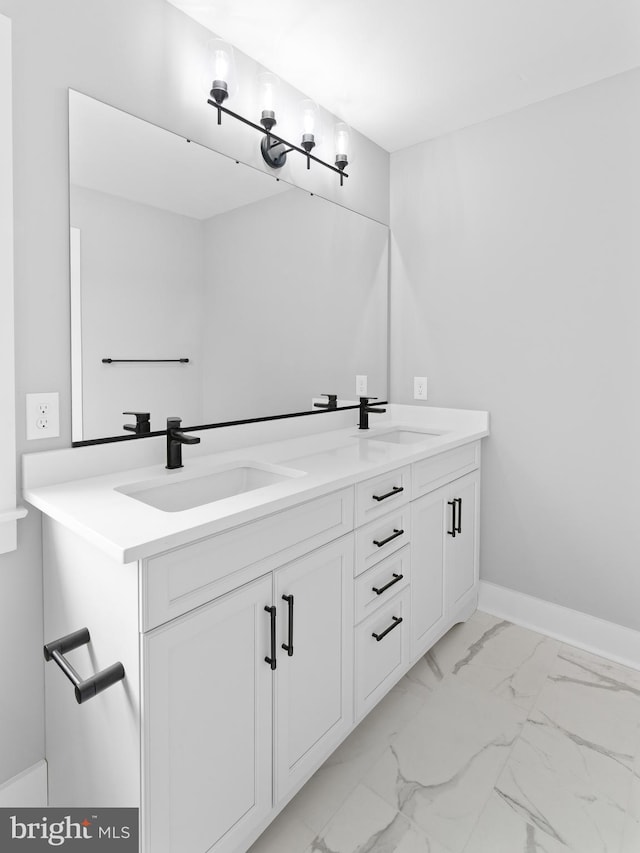 bathroom featuring a sink, baseboards, double vanity, and marble finish floor