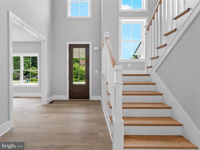 entrance foyer featuring wood finished floors, baseboards, and stairway