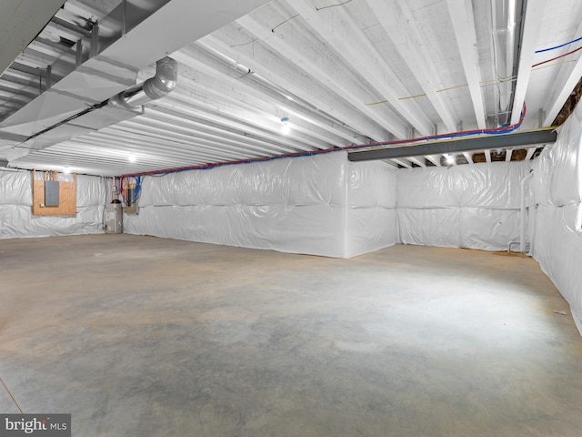 unfinished below grade area featuring electric panel and water heater
