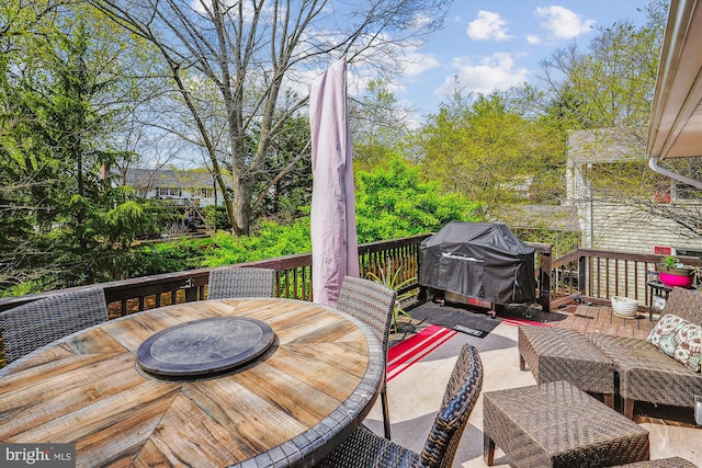 wooden deck featuring outdoor dining area and a grill