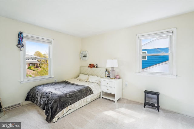 bedroom featuring visible vents and light colored carpet
