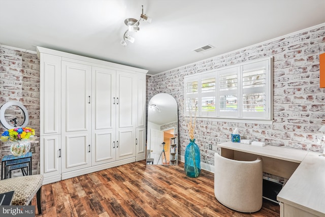 home office featuring visible vents, wallpapered walls, crown molding, and wood finished floors