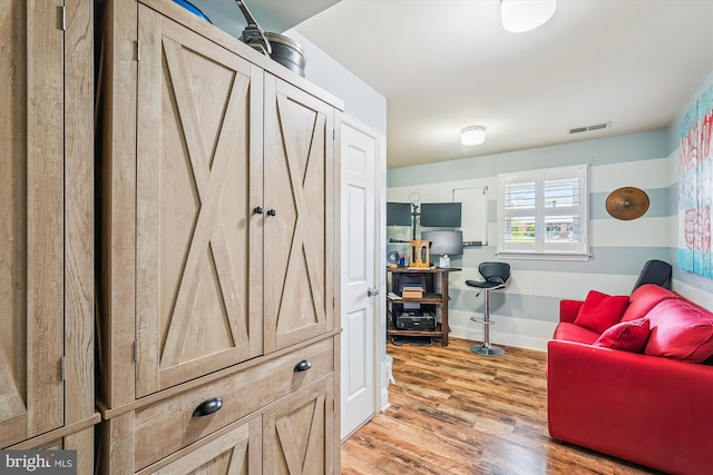 interior space with visible vents, baseboards, and wood finished floors